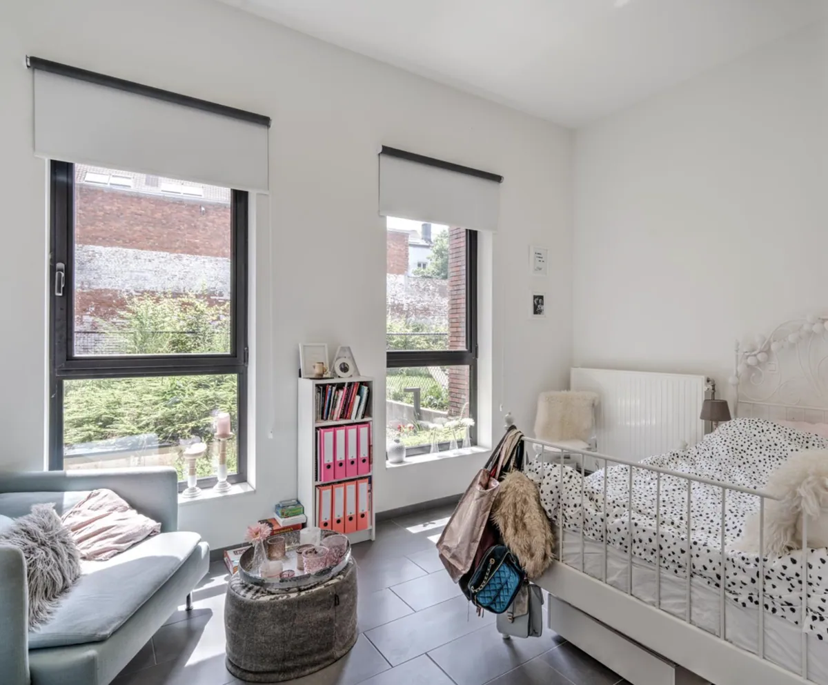 Lichte hoekkamer met twee ramen, bed en zithoek